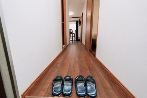 a row of shoes sitting on a shelf in a hallway at Nihonbashi Royal in Osaka