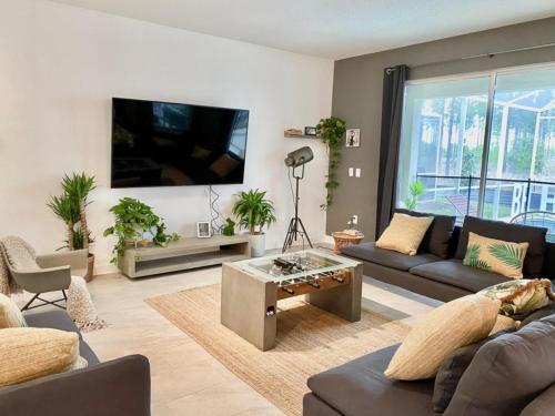 a living room with couches and a flat screen tv at Luxury 6 Bedroom 5 bath poolHome 214 in Orlando