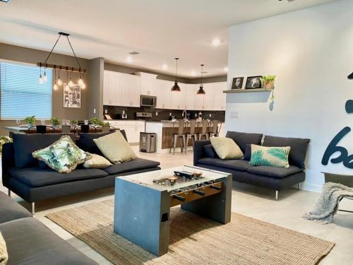 a living room with two couches and a kitchen at Luxury 6 Bedroom 5 bath poolHome 214 in Orlando