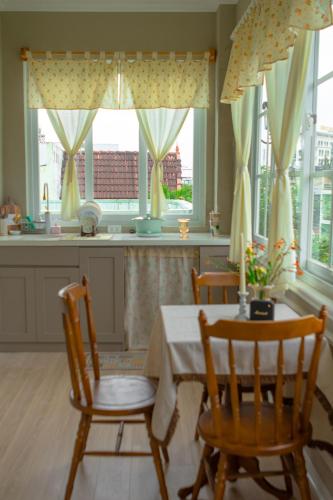 a kitchen with a table and chairs and windows at Camellia Full House in Da Nang