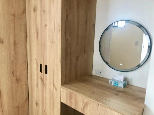 a bathroom with a mirror and a wooden cabinet at Casa en Laureles- Excelente Ubicación! in Medellín