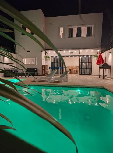 a swimming pool with green lighting in a house at LyL HURLINGHAM alojamiento privado in Hurlingham