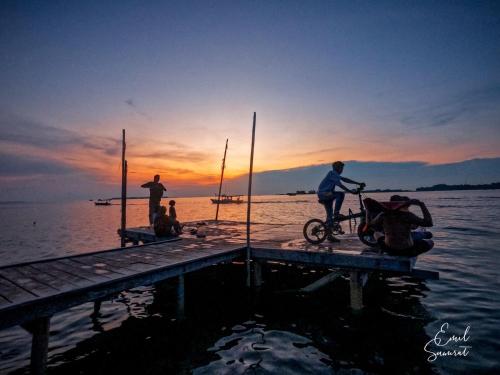 a group of people standing on a dock with a bike at Seribu Resort Thousand Island in Kepulauan Seribu