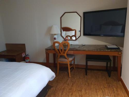 a bedroom with a desk with a television and a bed at Karak Tourist Hotel in Seoul