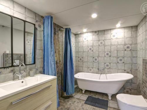 een badkamer met een bad, een toilet en een wastafel bij Gîte lumineux avec terrasse et animaux acceptés - FR-1-496-155 in Doizieux