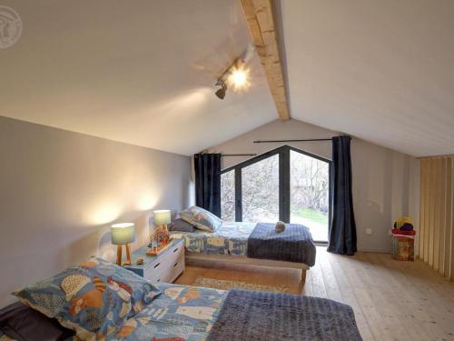 een slaapkamer met twee bedden en een raam bij Gîte lumineux avec terrasse et animaux acceptés - FR-1-496-155 in Doizieux