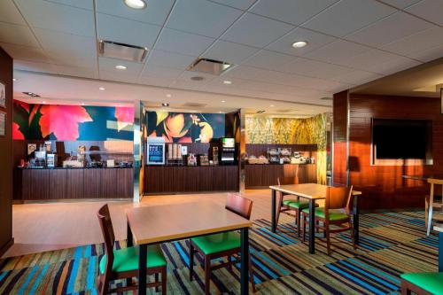 a restaurant with two tables and chairs and a tv at Fairfield by Marriott Inn & Suites Palm Desert Coachella Valley in Palm Desert