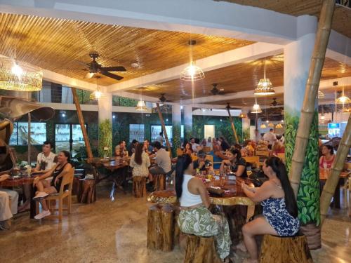 a group of people sitting at tables in a restaurant at Bonding Coffee Roaster Café & Hotel in Quepos