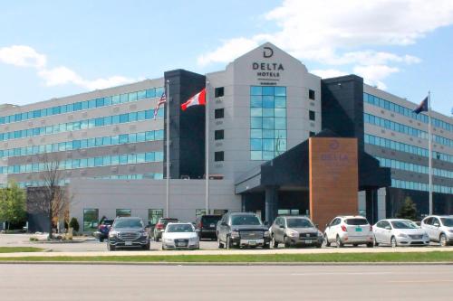 a building with cars parked in a parking lot at Delta Hotels by Marriott Fargo in Fargo