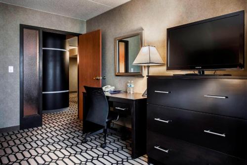 a hotel room with a desk and a flat screen tv at Delta Hotels by Marriott Fargo in Fargo