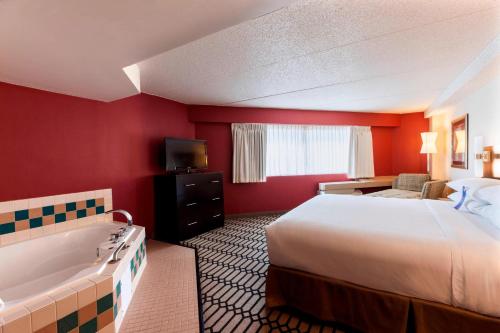 a hotel room with a bed and a bath tub at Delta Hotels by Marriott Fargo in Fargo