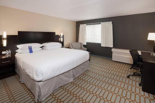 a hotel room with a large bed and a desk at Delta Hotels by Marriott Fargo in Fargo