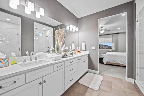Un baño con dos lavabos y un espejo grande. en Ouray Street - Commerce City, en Henderson