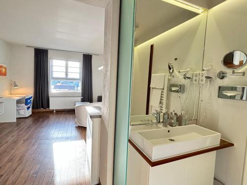 een badkamer met een wastafel en een spiegel bij Pier 11 im Pierspeicher in Kappeln