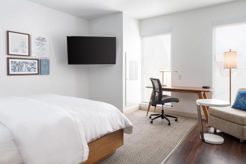 a bedroom with a bed and a desk and a chair at Element Iowa City in Iowa City