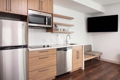 a kitchen with a stainless steel refrigerator and a tv at Element Iowa City in Iowa City