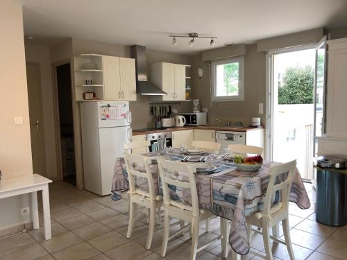 Il comprend une cuisine équipée d'une table et de chaises. dans l'établissement Maison lumineuse proche plage, Wifi, séjour idéal à Saint Jean de Monts - FR-1-323-557, à Saint-Jean-de-Monts