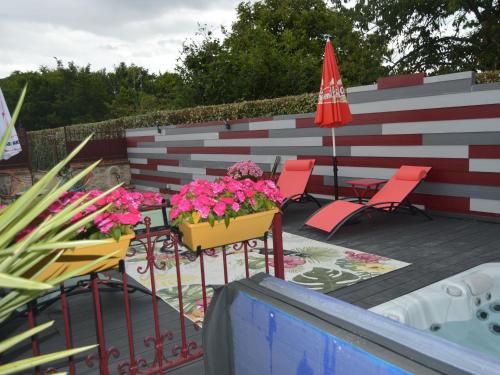 un patio avec des chaises et une table avec des fleurs et un parasol dans l'établissement Maison de Ville avec Spa et Sauna près d'Orléans - FR-1-590-547, à Chécy