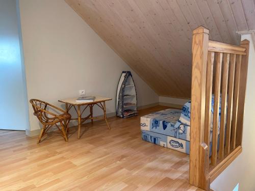 Cette chambre mansardée comprend un lit, une table et un bureau. dans l'établissement Maison lumineuse proche plage, Wifi, séjour idéal à Saint Jean de Monts - FR-1-323-557, à Saint-Jean-de-Monts