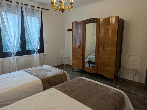 a bedroom with two beds and a dresser and a mirror at Maison moderne avec jardin, animaux acceptés, Wi-Fi, stationnement privé - FR-1-590-539 in Épieds-en-Beauce