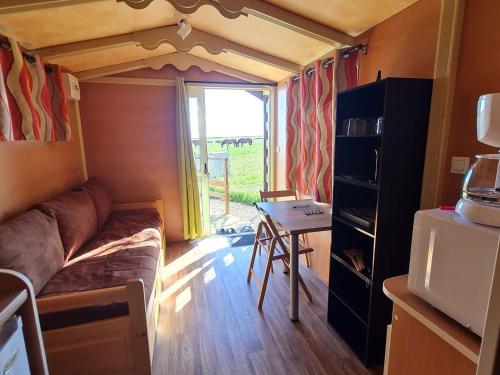un petit salon avec un canapé et une table dans l'établissement Roulotte Bohème Confort au Sud de Nancy - FR-1-584-364, à Burthecourt-aux-Chênes