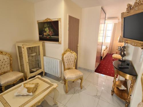 a living room with chairs a table and a tv at Appartement Délire Baroque à Sully-sur-Loire avec Climatisation - FR-1-590-557 in Sully-sur-Loire