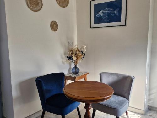 a table and two chairs and a vase with flowers at Grand Gîte à Briare - Animaux et Parking Privé - FR-1-590-541 in Briare