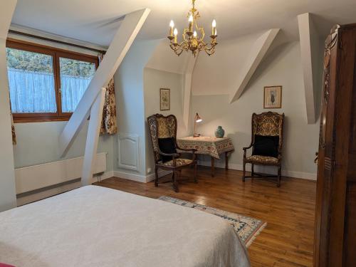 a bedroom with a bed and a table and chairs at Gîte Sologne 4* pour 7 pers., jardin, rando, proche Orléans - FR-1-590-552 in Ligny-le-Ribault