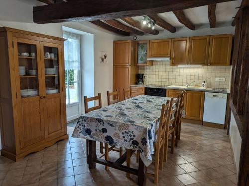 Il comprend une cuisine avec une table, des chaises et une table. dans l'établissement Gîte cosy rénové avec jardin, Wi-Fi et animaux acceptés près d'Orléans - FR-1-590-559, à Épieds-en-Beauce