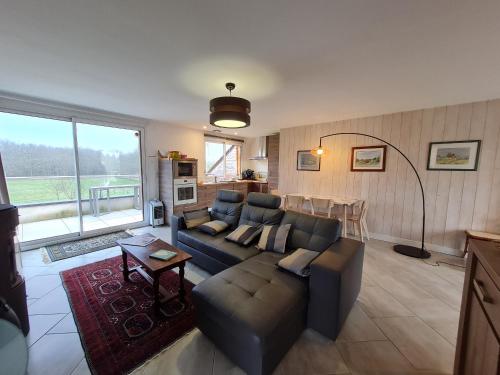 a living room with a couch and a table at Gîte en Sologne avec loisirs et activités proches - FR-1-590-554 in Jouy-le-Potier
