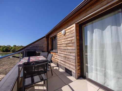 a balcony with a table and a large window at Gîte en Sologne avec loisirs et activités proches - FR-1-590-554 in Jouy-le-Potier