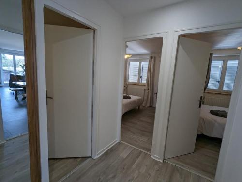 a room with two doors and a room with a bedroom at Gîte spacieux près du lac avec spa, aire de jeux, wifi et activités variées - FR-1-589-767 in Chaumousey