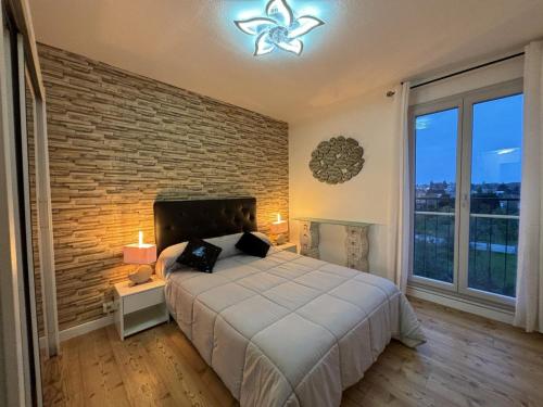 une chambre avec un grand lit et un mur de briques dans l'établissement Appartement confortable, proche centre-ville, idéal pour 4 personnes - FR-1-489-555, à Moulins