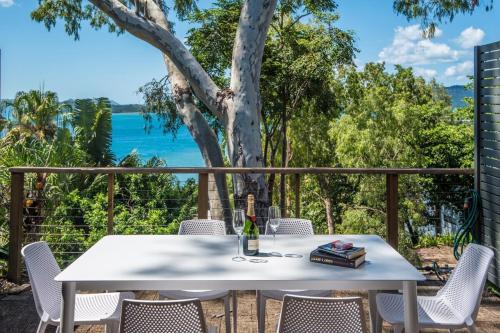 a white table and chairs with a view of the water at Sunset Waters 15 & Free Buggy- Hamilton Island in Hamilton Island