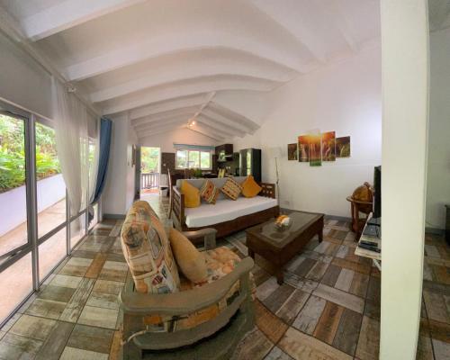 a living room with a couch and a table at Stephna Residence in Anse Boileau