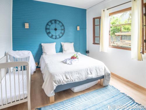 a blue bedroom with a bed and a clock on the wall at Villa spacieuse avec jardin, cheminée et billard, 5 chambres pour 10 pers. - FR-1-786-35 in Les Avirons
