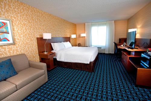 a hotel room with a bed and a couch and a desk at Fairfield Inn & Suites by Marriott Denver Aurora/Medical Center in Aurora