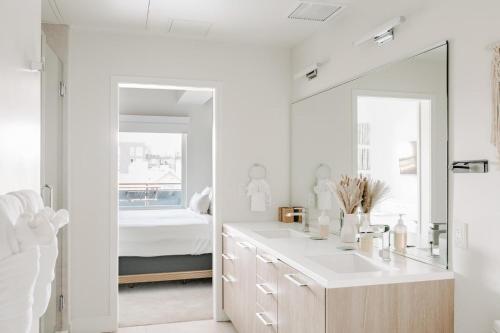 a white bathroom with a sink and a mirror at Contemporary Cool Lifestyle Loft - Zuni Lofts in Denver