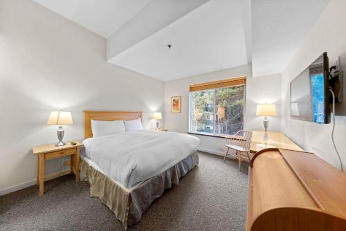 a bedroom with a large bed and a window at Palisades Tahoe Lodge Rentals Two Bedroom #521 in Olympic Valley