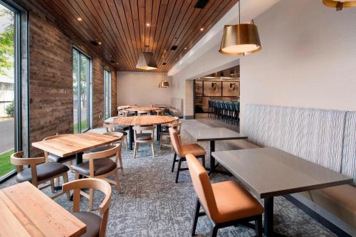 a restaurant with tables and chairs and windows at Delta Hotels by Marriott Seattle Everett in Everett