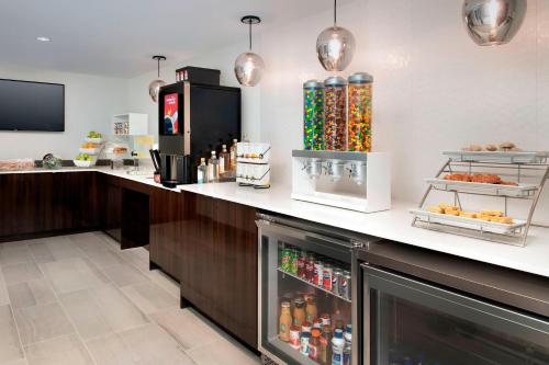 a restaurant with a counter with a refrigerator at Delta Hotels by Marriott Seattle Everett in Everett