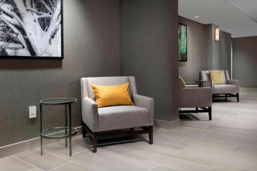 a waiting room with a chair with a yellow pillow at Delta Hotels by Marriott Seattle Everett in Everett