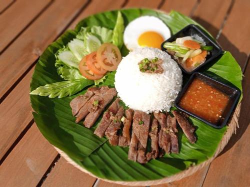 a plate of food with rice and meat and vegetables at Thisak Resort Cheung phnom kulen in Siem Reap