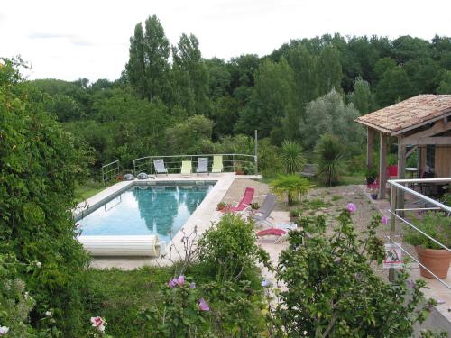 a swimming pool in a yard with a house at B&B Les Secrets de Tifayne in Puisseguin