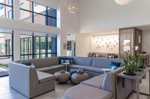 a living room with a blue couch and chairs at Element Dallas Richardson in Richardson