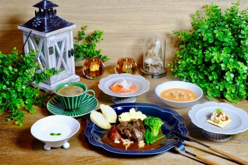 a table with a plate of food and bowls of food at Almeria Hotel in Yamanakako