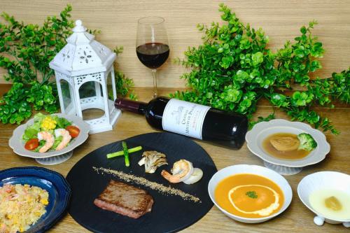a table with a plate of food and a bottle of wine at Almeria Hotel in Yamanakako