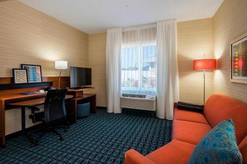 a hotel room with a desk and a couch and a computer at Fairfield Inn & Suites by Marriott Little Rock Benton in Benton