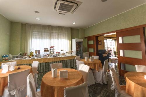 a restaurant with tables and chairs and a bar at Hotel Aquila in Orte