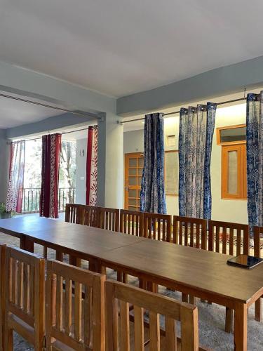 a dining room with a large wooden table and chairs at Himalaya view cottage, machkhali , Ranikhet in Shitlakhet